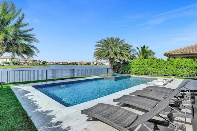 view of swimming pool featuring pool water feature, a water view, and an in ground hot tub