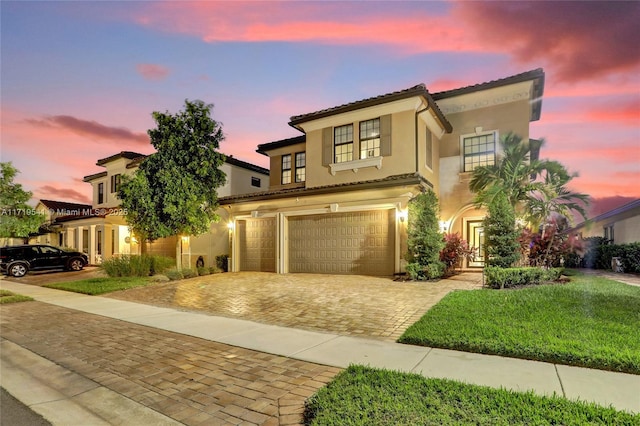 mediterranean / spanish-style home with a lawn and a garage