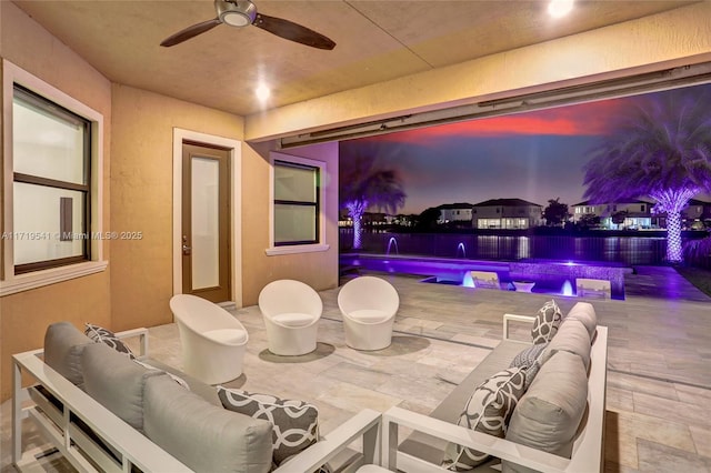 patio terrace at dusk featuring an outdoor living space, pool water feature, and ceiling fan