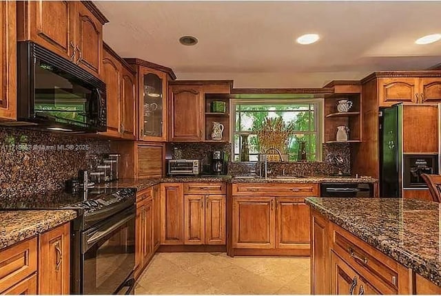 kitchen featuring light tile patterned floors, decorative backsplash, dark stone countertops, black appliances, and sink