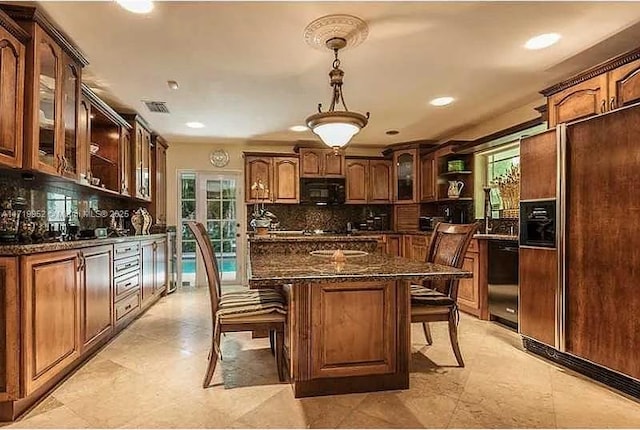 kitchen featuring black appliances, a breakfast bar, dark stone countertops, and a healthy amount of sunlight