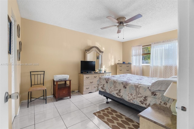 tiled bedroom with ceiling fan and a textured ceiling