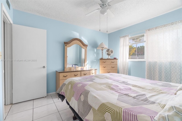 tiled bedroom featuring ceiling fan and a textured ceiling