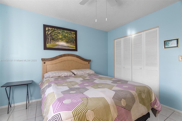 bedroom with light tile patterned floors, a textured ceiling, a closet, and ceiling fan