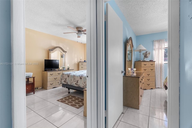 tiled bedroom featuring ceiling fan and a textured ceiling