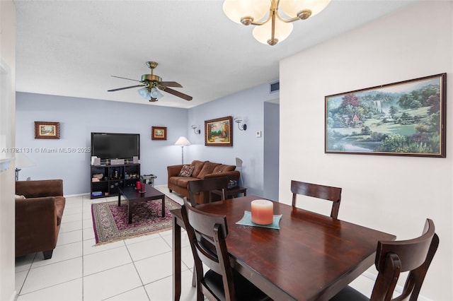 dining area with ceiling fan with notable chandelier and light tile patterned flooring