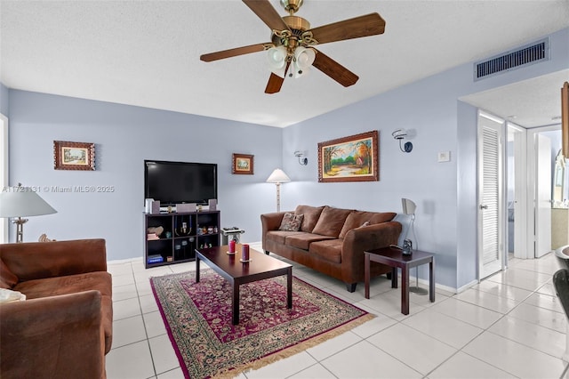 tiled living room featuring a textured ceiling and ceiling fan