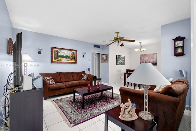 tiled living room with ceiling fan with notable chandelier