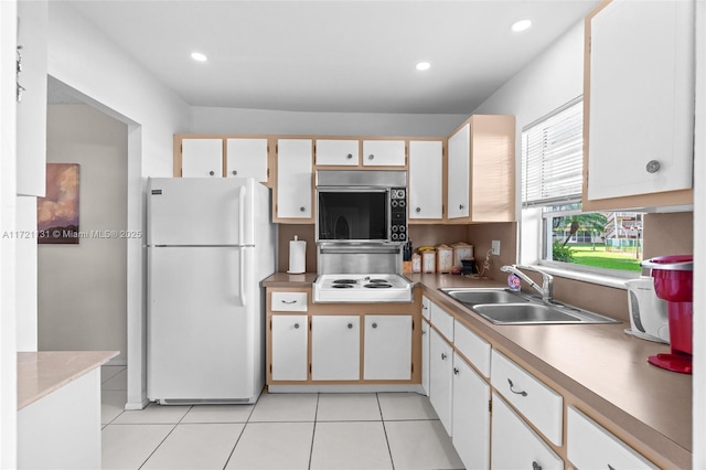 kitchen with sink, white cabinets, white appliances, and light tile patterned floors