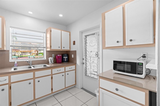 kitchen featuring sink, white cabinets, and light tile patterned floors