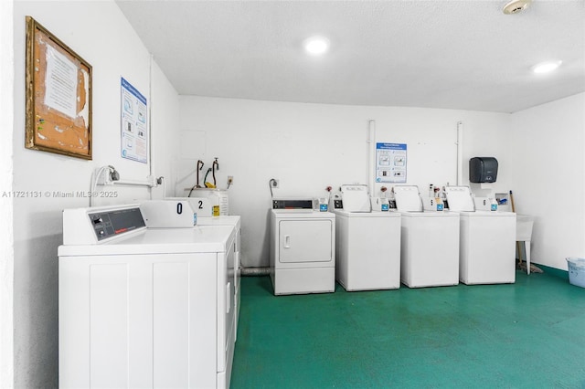 laundry area featuring water heater, a textured ceiling, and independent washer and dryer