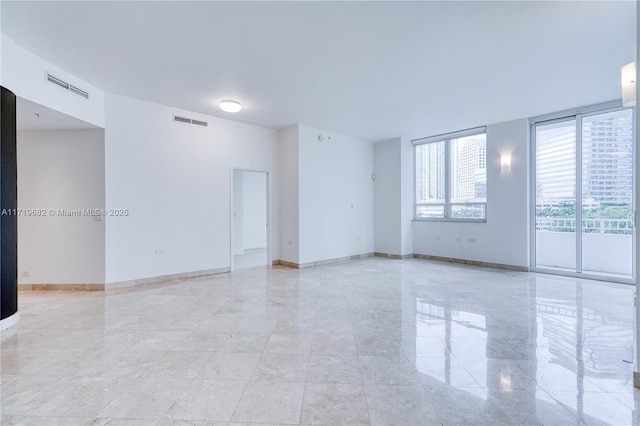 unfurnished room featuring visible vents and baseboards