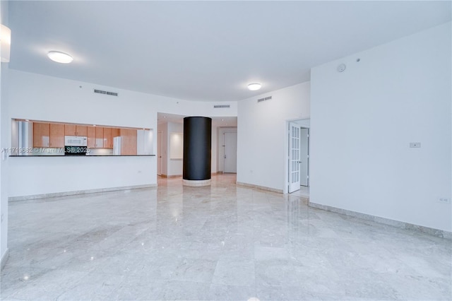 unfurnished living room featuring baseboards and visible vents