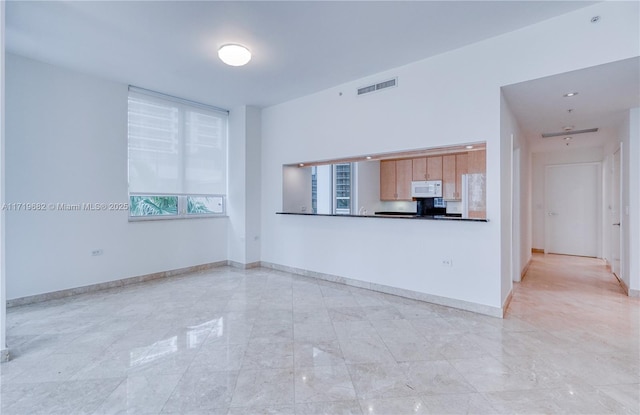 kitchen featuring dark countertops, visible vents, baseboards, and white microwave