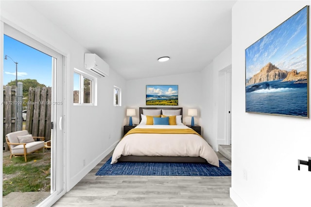 bedroom featuring light wood-type flooring, access to outside, a wall unit AC, and vaulted ceiling