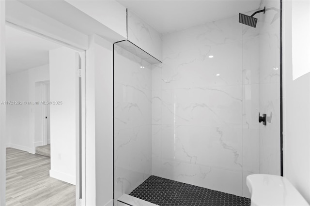 bathroom with hardwood / wood-style flooring and tiled shower