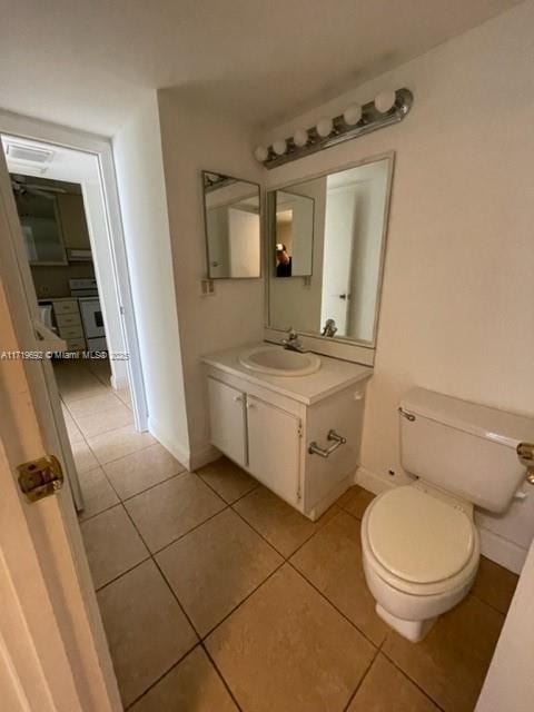 bathroom featuring vanity, toilet, and tile patterned flooring