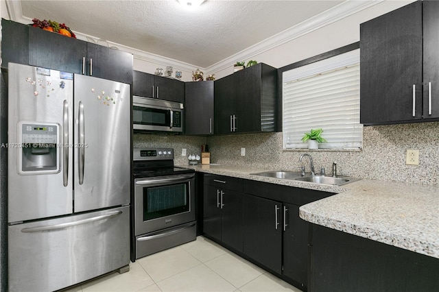 kitchen with sink, stainless steel appliances, a textured ceiling, light tile patterned flooring, and ornamental molding