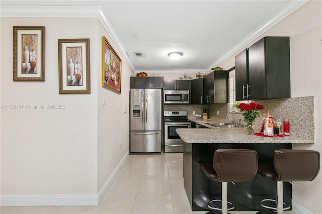 kitchen featuring kitchen peninsula, a kitchen breakfast bar, stainless steel appliances, and sink