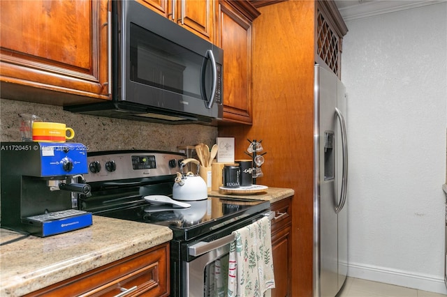 kitchen with decorative backsplash, light tile patterned floors, stainless steel appliances, and ornamental molding