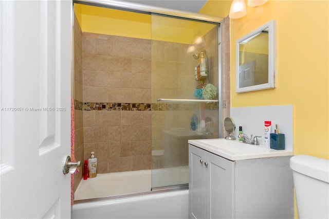 full bathroom with vanity, toilet, and enclosed tub / shower combo