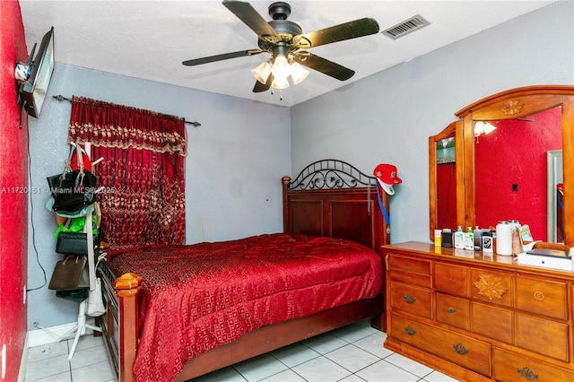 tiled bedroom with ceiling fan and a textured ceiling