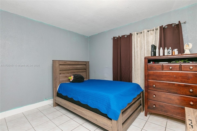 bedroom with light tile patterned floors and a textured ceiling