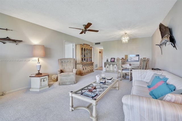 carpeted living room featuring ceiling fan with notable chandelier and a textured ceiling