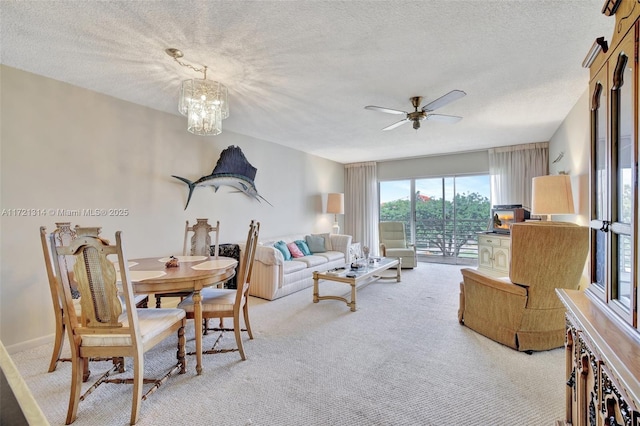 carpeted living room featuring a textured ceiling and ceiling fan with notable chandelier