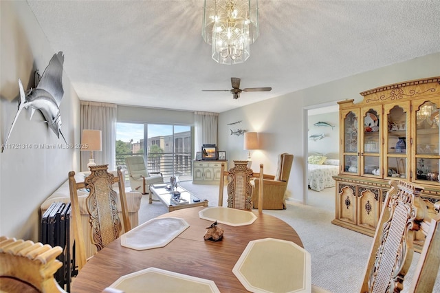 dining space with a textured ceiling, ceiling fan with notable chandelier, and light carpet