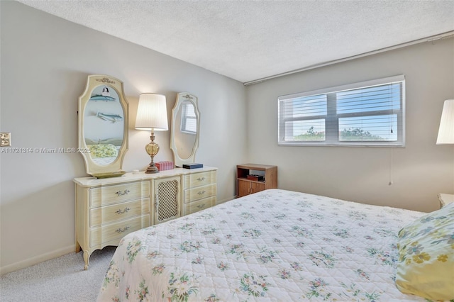 bedroom featuring light carpet and a textured ceiling