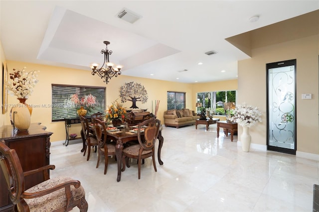 dining room featuring a tray ceiling and an inviting chandelier