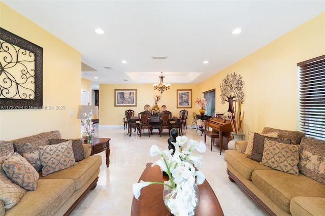 living room featuring a notable chandelier and a raised ceiling