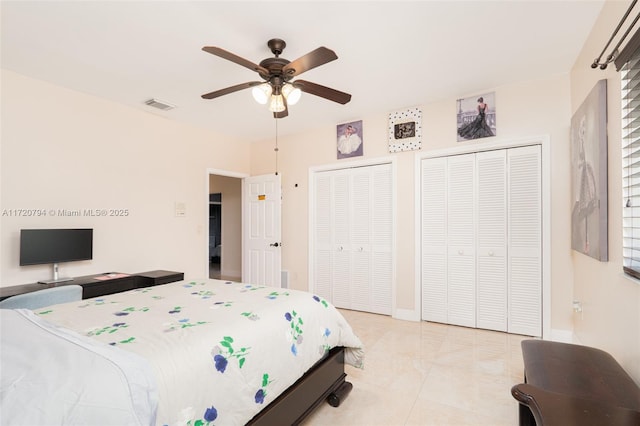 bedroom featuring two closets, ceiling fan, and light tile patterned flooring