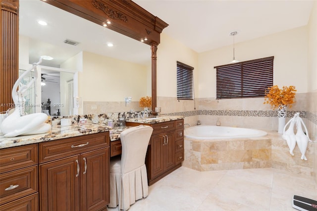 bathroom with tiled bath, ceiling fan, tile patterned flooring, and vanity