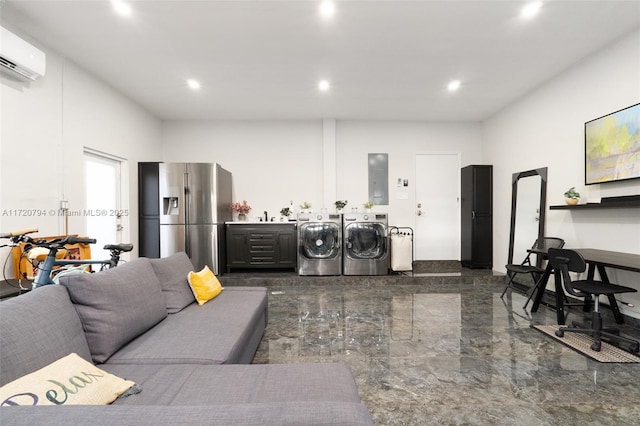 living room with a wall mounted air conditioner, electric panel, and washing machine and clothes dryer