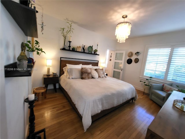 bedroom with dark wood-type flooring and a chandelier