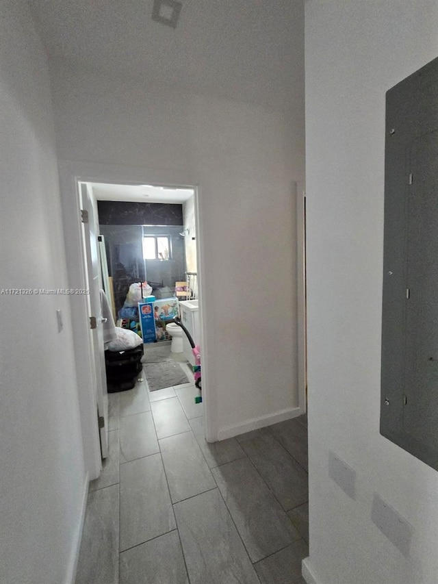 corridor with light tile patterned floors and electric panel