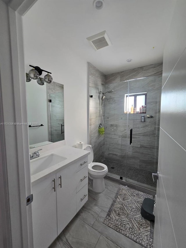 bathroom featuring vanity, an enclosed shower, and toilet