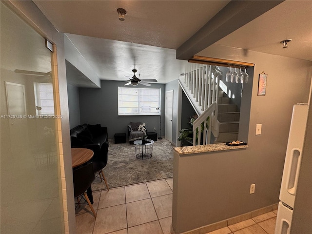 kitchen featuring ceiling fan, white fridge, light tile patterned floors, and beam ceiling