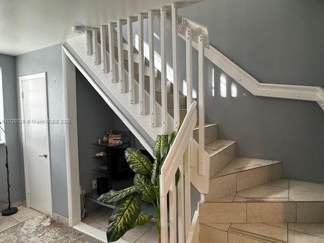 stairway with tile patterned flooring