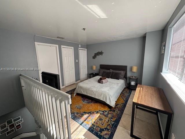 bedroom featuring light tile patterned floors and two closets