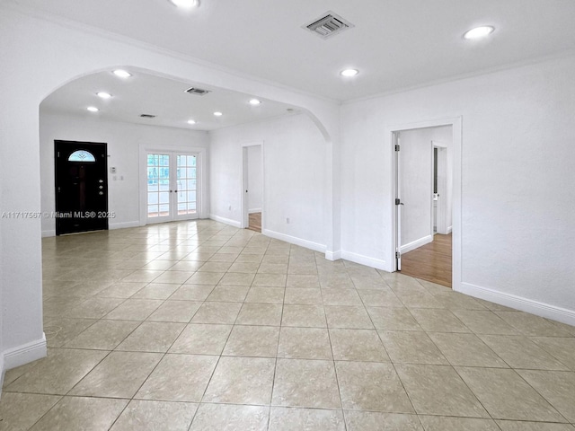 spare room featuring crown molding, french doors, and light tile patterned floors