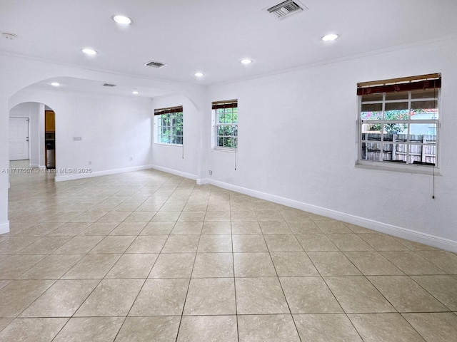 tiled empty room featuring crown molding