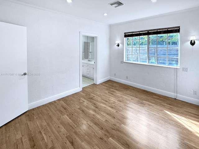 unfurnished bedroom with light hardwood / wood-style floors, ensuite bath, and crown molding