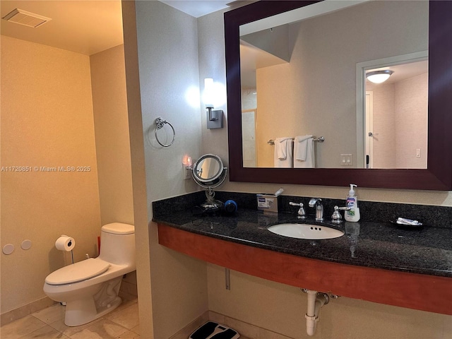 bathroom featuring toilet, sink, and tile patterned flooring