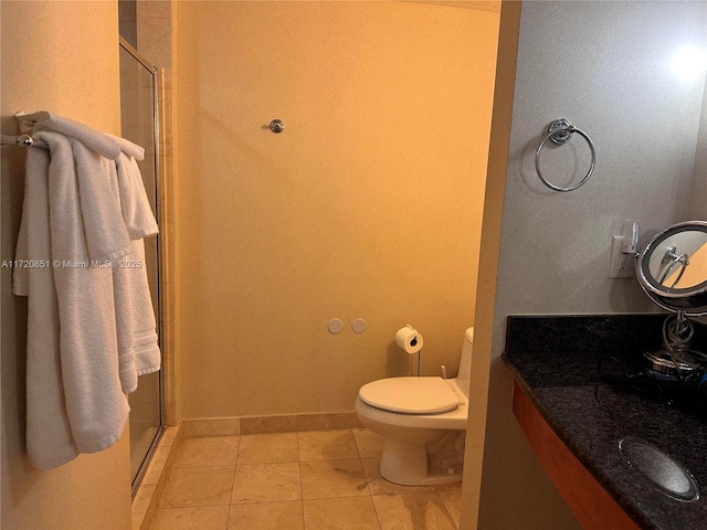 bathroom featuring tile patterned floors, vanity, toilet, and walk in shower