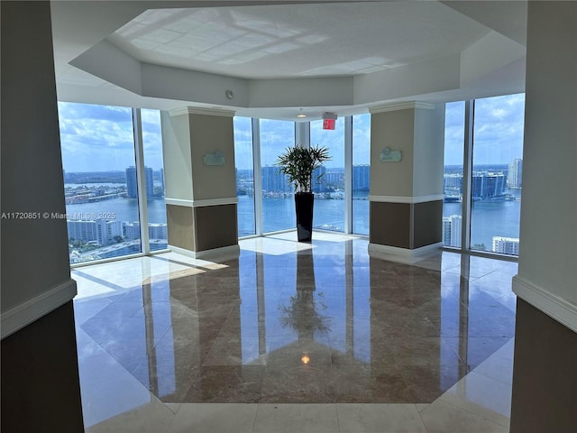 unfurnished room with a water view and floor to ceiling windows