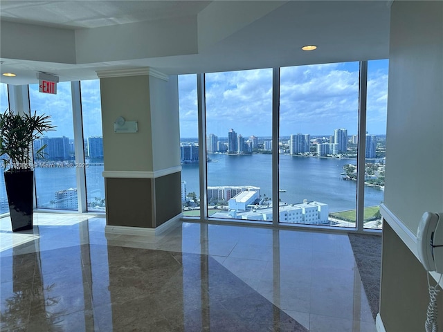 interior space with a water view, expansive windows, and a healthy amount of sunlight