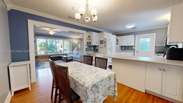 dining room featuring ceiling fan with notable chandelier, ornamental molding, and light wood-type flooring